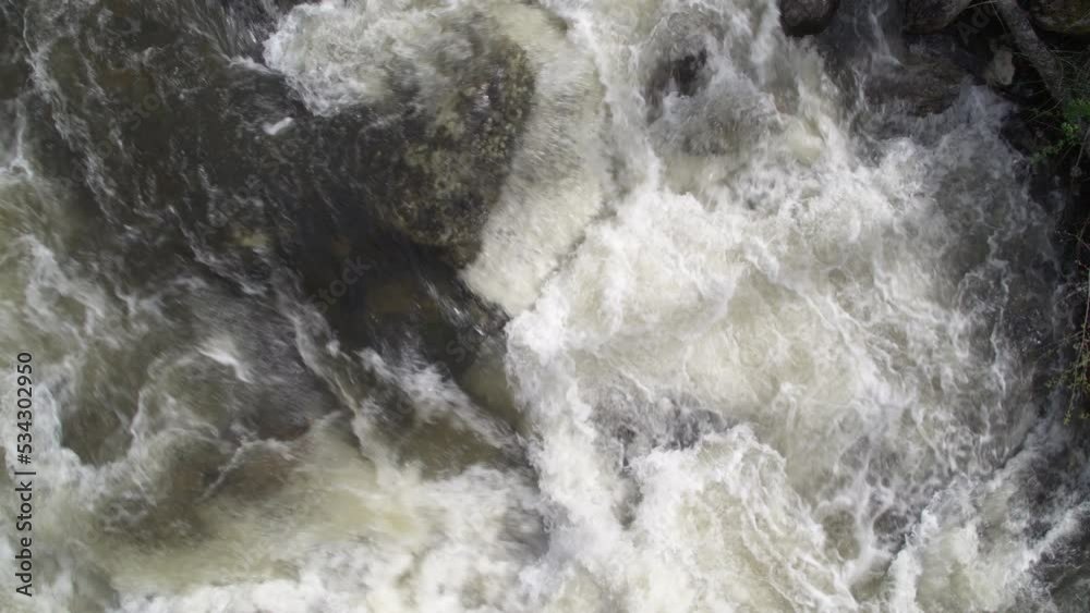Top down close up aerial of white water creek and ascending over green forested riverbanks in Idaho Top down close up aerial of white water creek and ascending over green forested riverbanks in Idaho