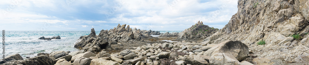 Fototapeta premium sharp jagged basalt rocks on the sea coast, Cape Stolbchaty on Kunashir Island