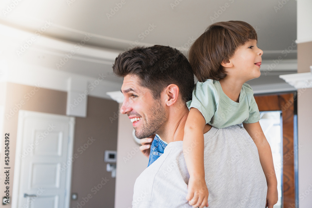 Smiling father holding son playing in the living room being a happy family Smiling father holding son playing in the living room being a happy family