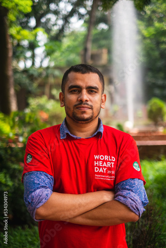 South asian young male medical student wearing red t shirt in awareness about world heart day campaign 