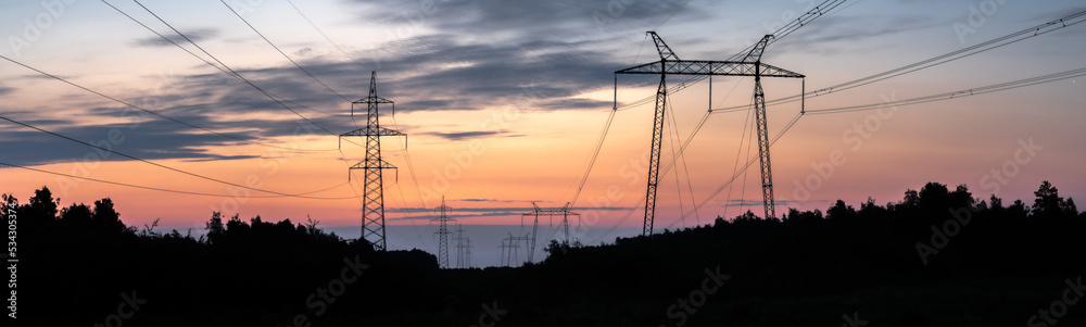 wide panorama of power lines against the sky of sunrise colors