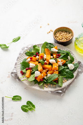 Close up of roasted butternut pumpkin healthy salad on white plate food concept