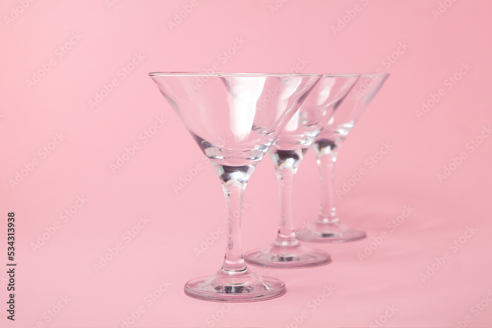 Obraz premium Empty martini glasses on a pink background. Cocktail glasses