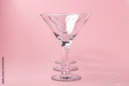 Empty martini glasses on a pink background. Cocktail glasses