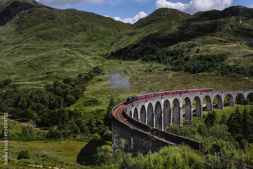 The Jacobite train passes over the Glenfinnan Viaduct in Scotland photo