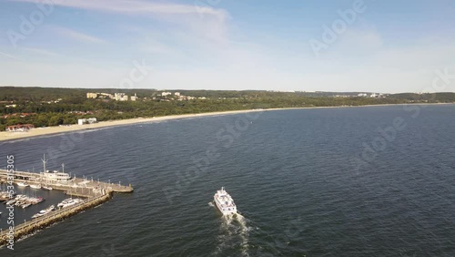 View from the drone on the pier in Sopot on the Baltic Sea on a sunny,autumn day and on a cruise ship arriving at the pier. photo