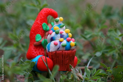 A figure of a dwarf with a cupcake in his hand.