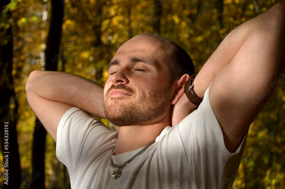 Fototapeta premium candid portrait of a strong young man in sunlight