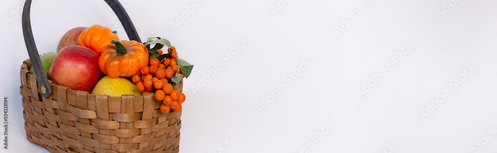 wicker basket full of fruit vegetables berries on a white background, thanksgiving day, autumn, harvest, gardening, farming, pumpkin, apples, rowan, orange, halloween, seasonal holiday, space for text wicker basket full of fruit vegetables berries on a white background, thanksgiving day, autumn, harvest, gardening, farming, pumpkin, apples, rowan, orange, halloween, seasonal holiday, space for text