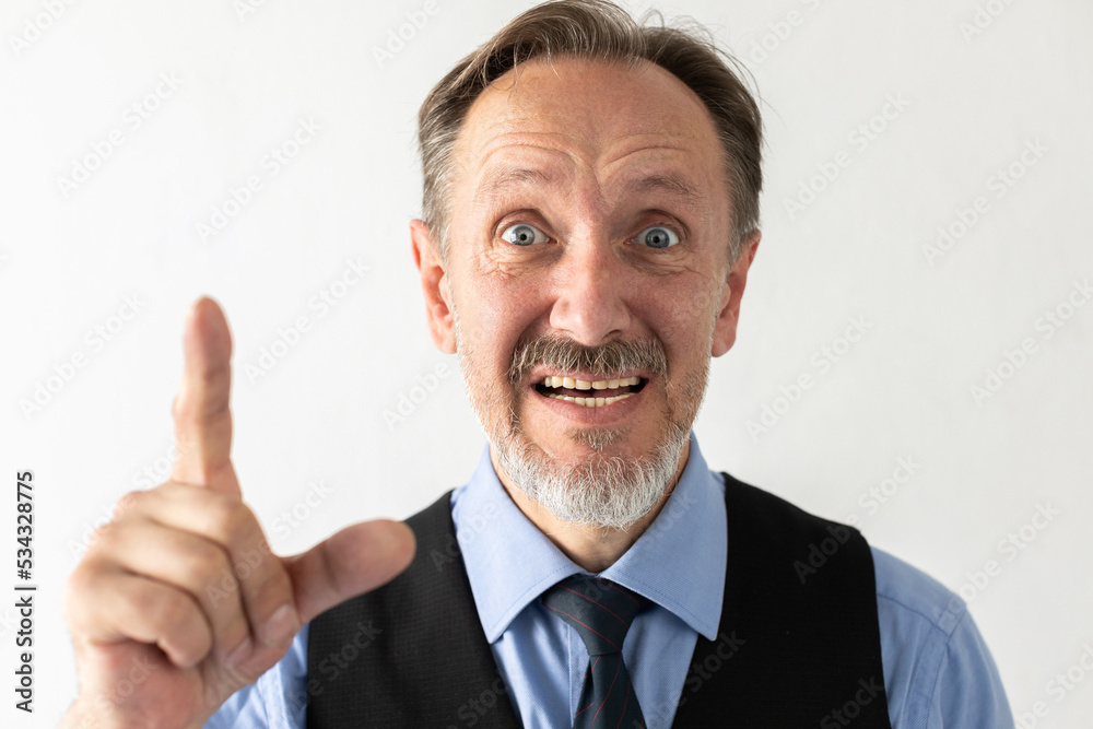 Portrait of excited mature businessman making idea gesture. Senior Caucasian manager wearing formalwear looking at camera, talking and showing forefinger against white background. Idea concept Portrait of excited mature businessman making idea gesture. Senior Caucasian manager wearing formalwear looking at camera, talking and showing forefinger against white background. Idea concept