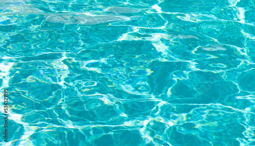 turquoise color background of swimming pool water with ripples in summertime