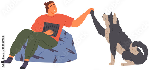 Pet owner plays with dog. Caring for animals, joint pastime with pets. Happy guy with puppy, domestic animal companion at home. Male character training doggy. Man spends time with dog and give five