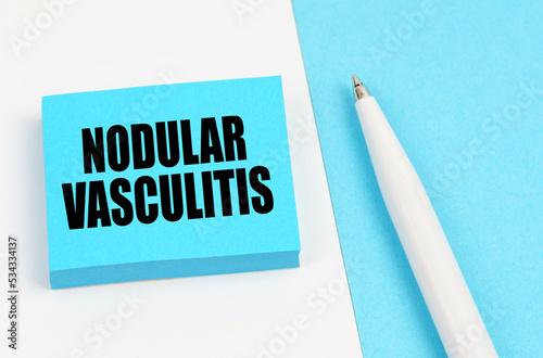 On a white and blue surface, a pen and blue stickers with the inscription - Nodular vasculitis photo