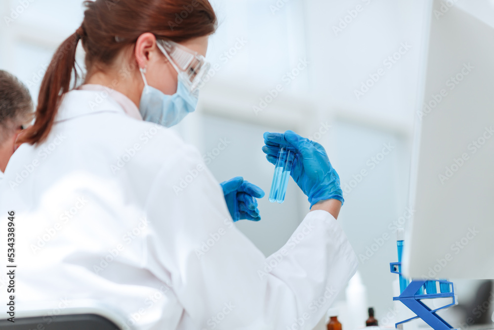 close up .female scientist looking at test tube . close up .female scientist looking at test tube .