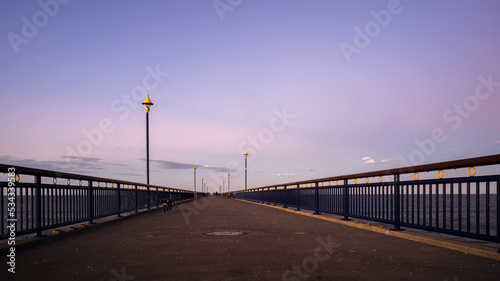 New Brighton Pier at sunset. Indistinctive people at end of the pier. Christchurch, New Zealand.