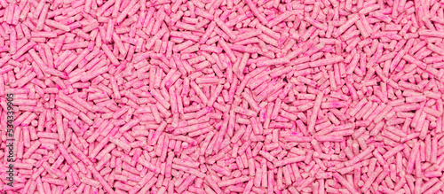 Pink soy pellets banner for texture or background. Cat litter product from tofu - soy bean panorama. Natural pink tofu pellets. A natural organic substance biodegradable and good for environment.