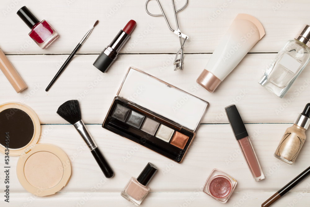 Different makeup products on wooden background, top view Different makeup products on wooden background, top view