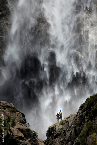 Male and female hikers admiring Yosemite Falls, Yosemite National Park, California