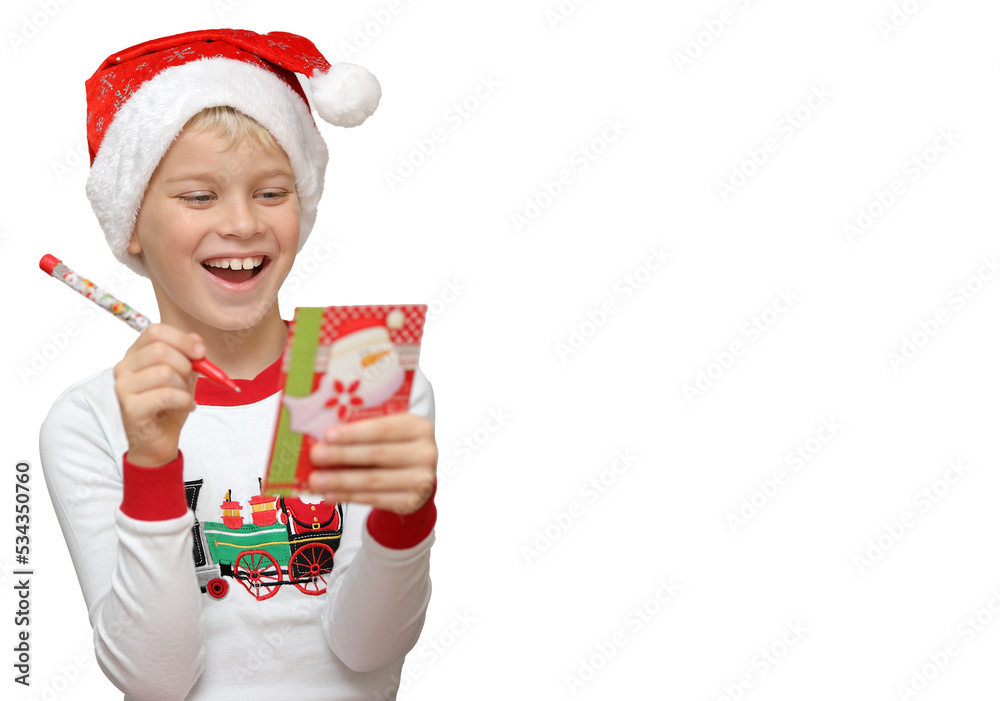 Obraz premium Cute little child wearing Santa hat and writing a wishlist on white background. Isolated object, christmas holiday