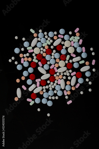 several colored pills on a black background