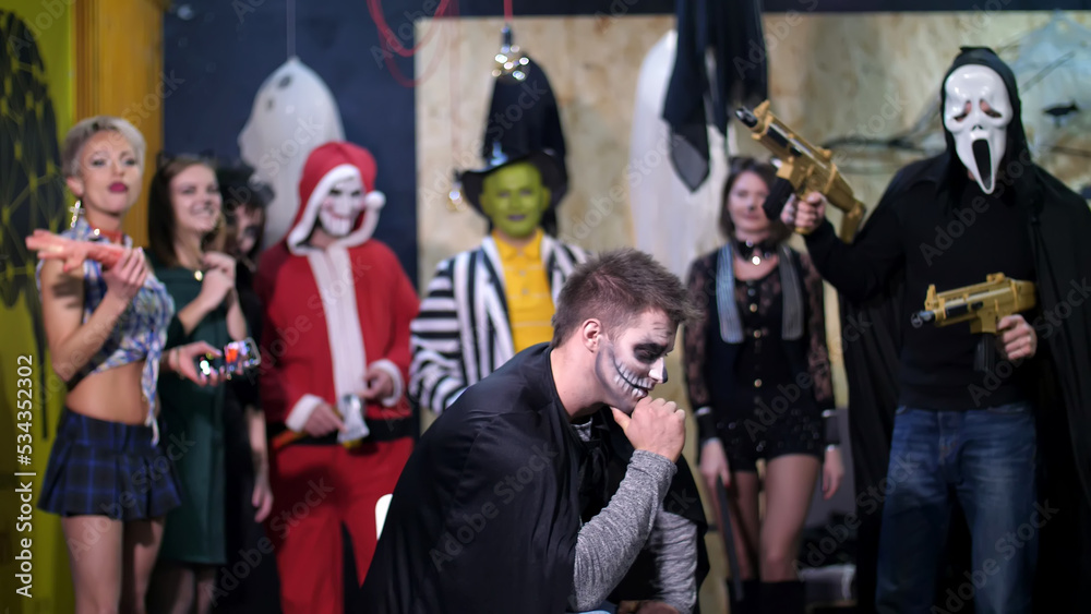 Halloween party, photo session, young people dressed up in scary costumes and made a horrific make-up. they are having fun, in the background Halloween scenery is seen. High quality photo Halloween party, photo session, young people dressed up in scary costumes and made a horrific make-up. they are having fun, in the background Halloween scenery is seen. High quality photo