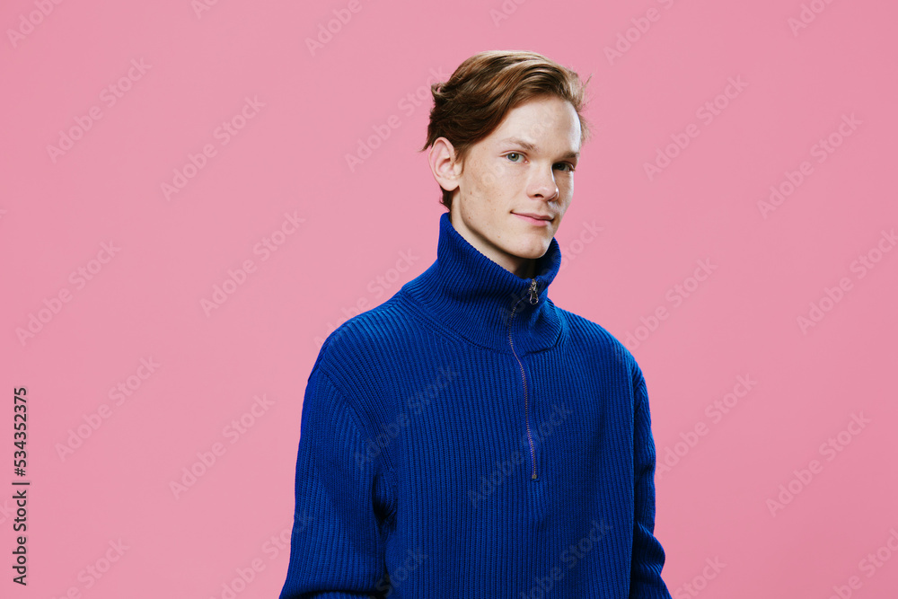 handsome pleasant young man in a blue zip sweater posing looking at the camera and smiling sweetly handsome pleasant young man in a blue zip sweater posing looking at the camera and smiling sweetly