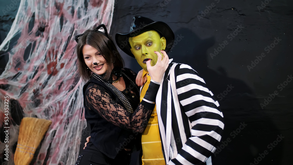 Halloween party, photo session, young people dressed up in scary costumes , with a horrific make-up. they are having fun, in the background Halloween scenery is seen. High quality photo