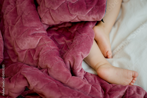 sleeping baby  legs feet under pink blanket