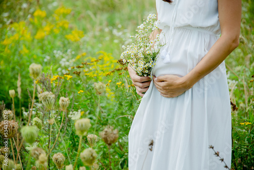 pregnant woman in a white dress in a field
