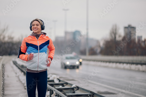 Woman running on the bridge at winter and snow.