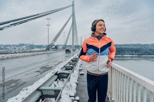 Woman running on the bridge at winter and snow.