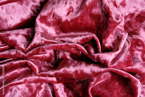 Randomly crumpled velvet fabric, abstract pink and burgundy background. space for lettering and design. Selective focus.