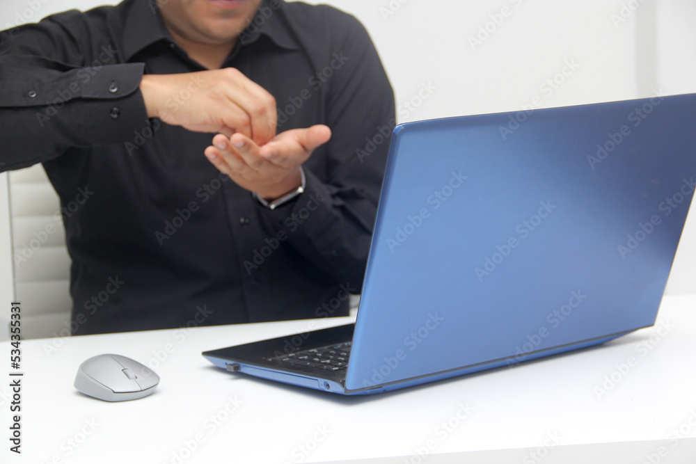 Latino adult man speaks Mexican sign language with a deaf person through a laptop in a video call Latino adult man speaks Mexican sign language with a deaf person through a laptop in a video call