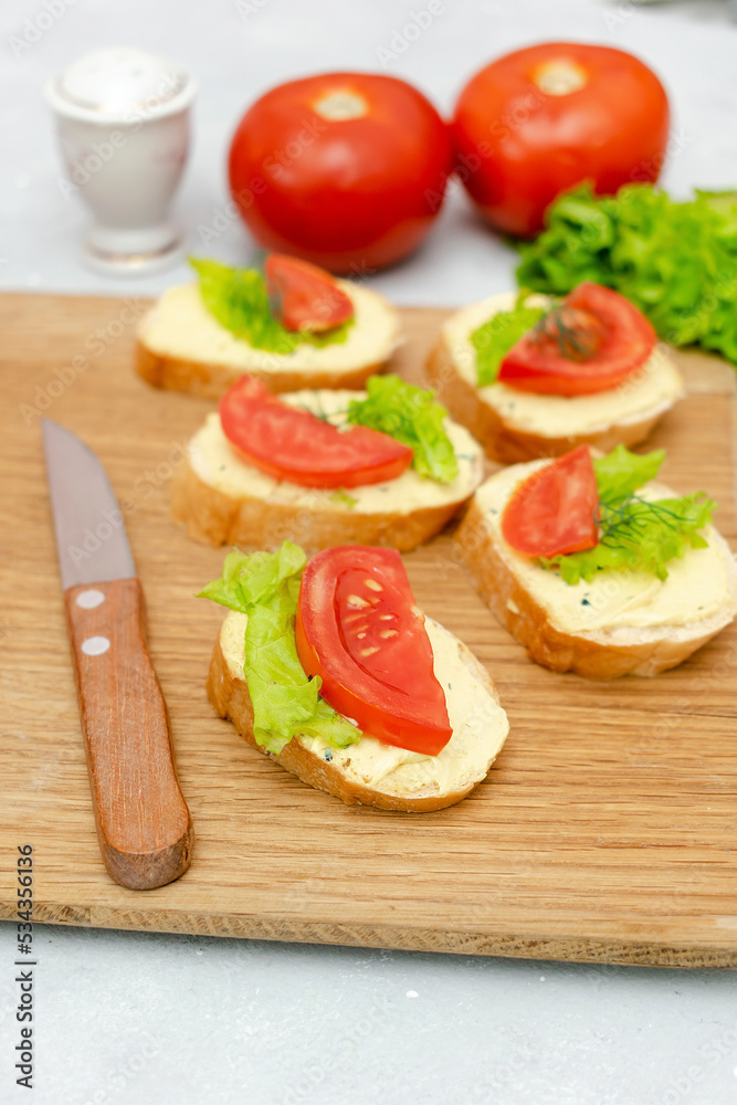 Bruschetta sandwich bread toast with soft white cheese ricotta,fresh tomatoes,basil greenery on a wooden cutting board.Tasty healthy vegetarian food,Italian cuisine appetizer. top view flat lay Bruschetta sandwich bread toast with soft white cheese ricotta,fresh tomatoes,basil greenery on a wooden cutting board.Tasty healthy vegetarian food,Italian cuisine appetizer. top view flat lay