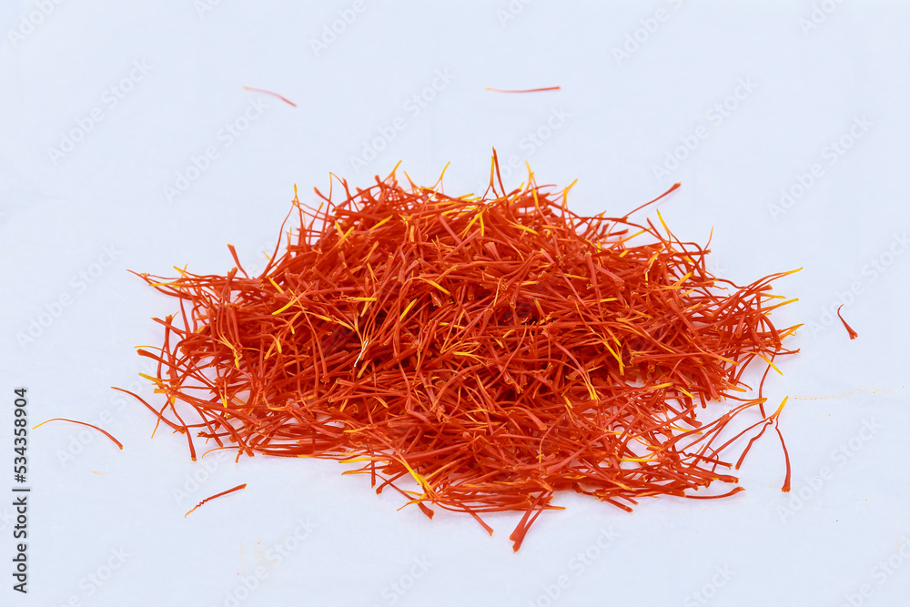 Fototapeta premium A pile of saffron stamens on a white background. Drying spices, use in cooking.