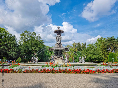 Beautiful fountain in the city park Stadtpark, a green island in the middle of the city center of Graz, Styria region, Austria. Selective focus © Aron M  - Austria