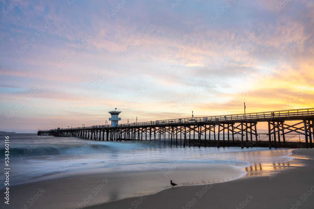 Vibrant Sunset burns over Seal Beach Pier Long Exposure Wave Photography 
