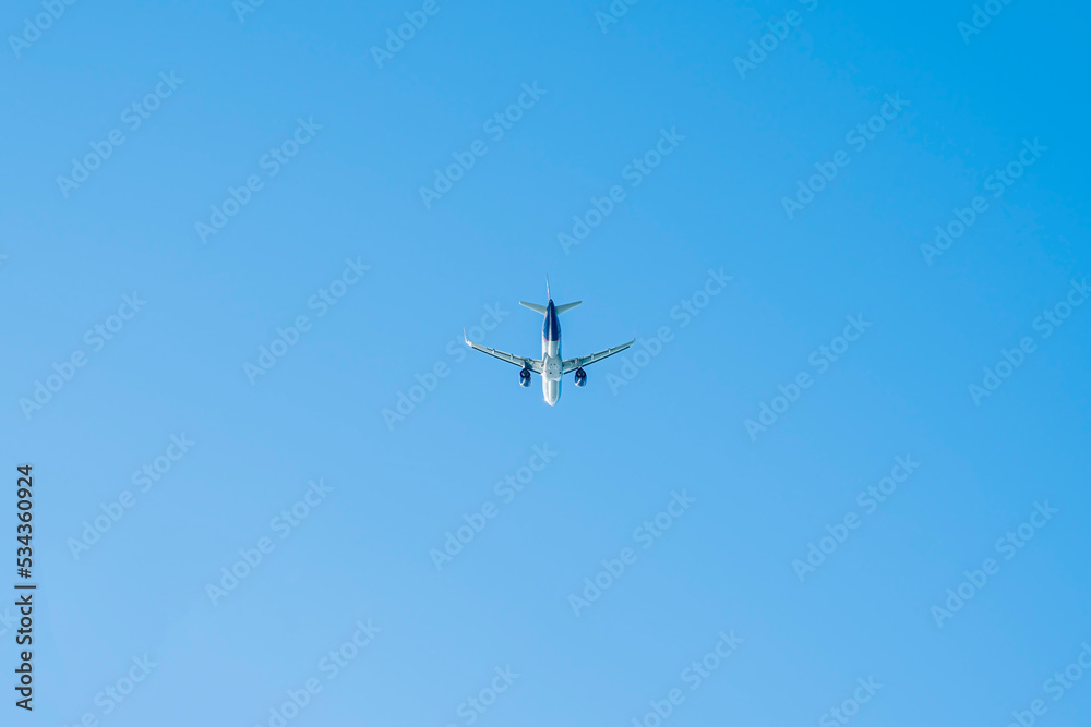 the plane is flying against the blue sky the plane is flying against the blue sky