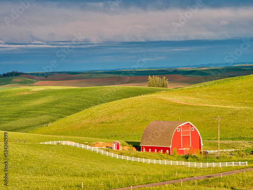 USA, Idaho, Palouse. Red barn with dark clouds and warm light