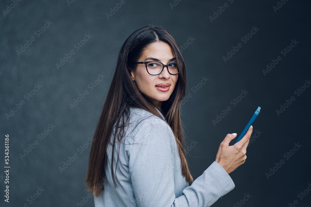 Business woman standing outside the office building and using smartphone Business woman standing outside the office building and using smartphone