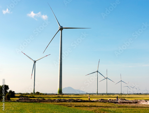 Wind turbine towers farm in a big field to generate electricity. Clean alternative energy concept to reduce global warming and climate change for sustainable growth.