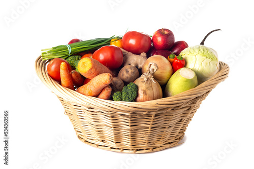 wicker basket with vegetables and fruits on white background.