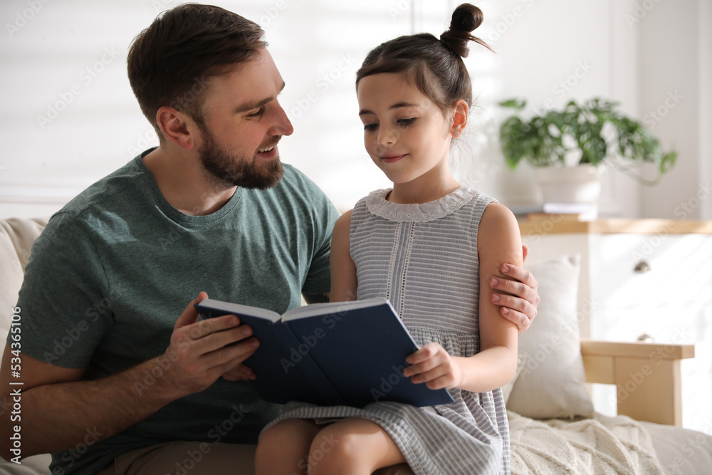 Little girl with father reading fairy tale in living room Little girl with father reading fairy tale in living room