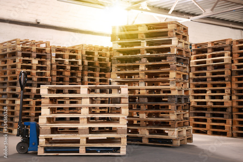 Modern manual forklift and wooden pallets in warehouse