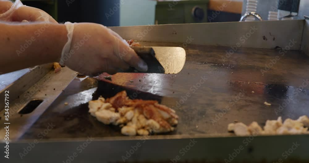 Close-up shot of chef cooking ingredients with a spatula on a grill. Close-up shot of chef cooking ingredients with a spatula on a grill.