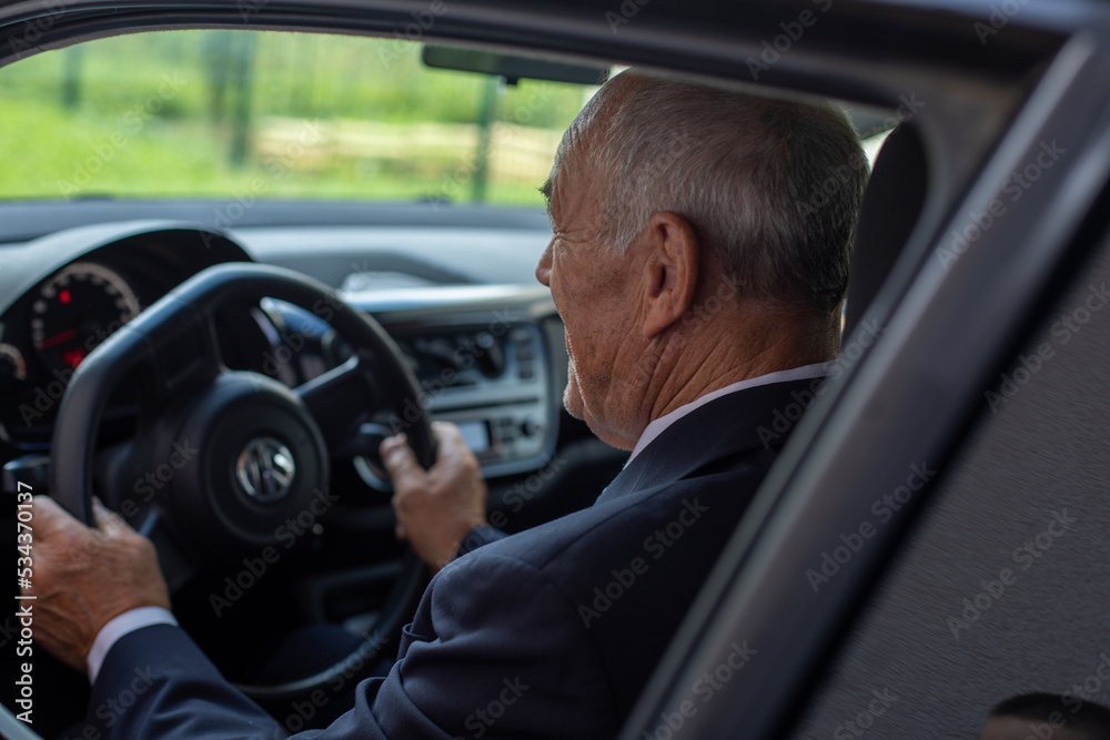 A senior man driving the car