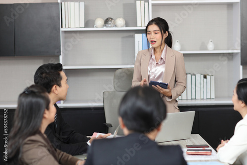 Collaborative process of professional businesspeople going over on new project together, using tablet presentation and brainstorming ideas, coworker and working together at office meeting concept