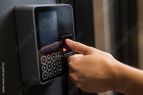 A woman opens the door with her fingerprint. Modern keyless entry lock. 