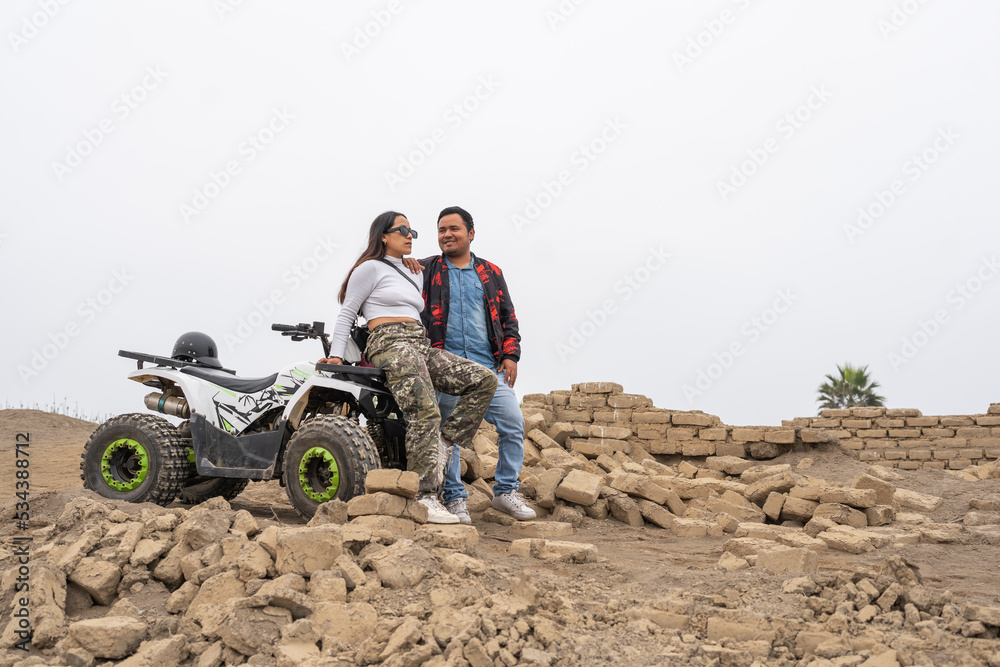 Fototapeta premium Couple sitting on a quad bike on a beach