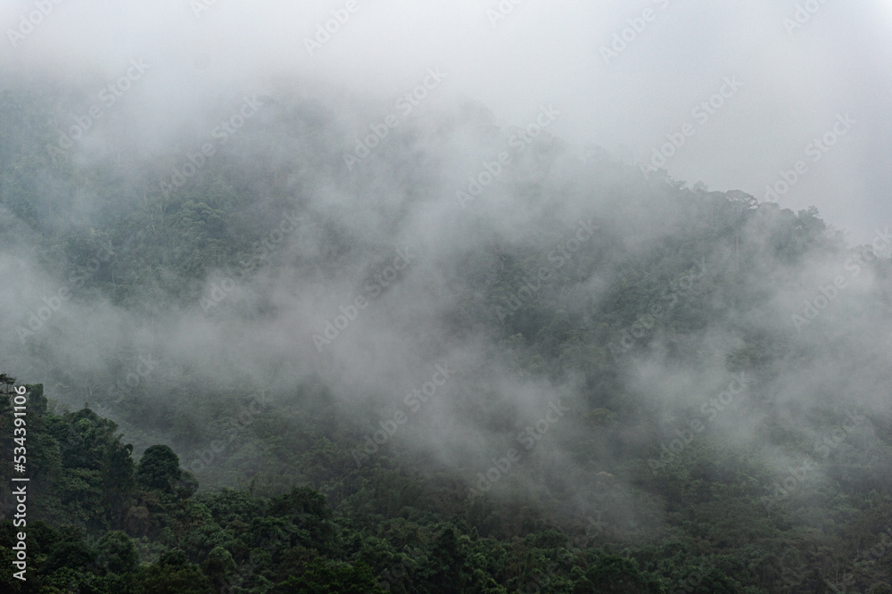 Mountain range with visible silhouettes through the morning colorful fog.